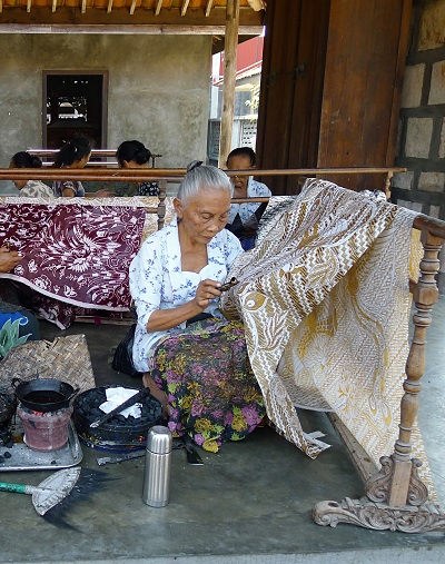 A woman making batik (wax resist dyed fabric)
