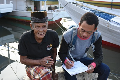A young man interviewing an elderly fisherman