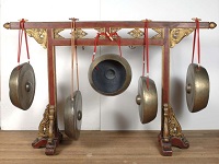 A series of gongs suspended from a frame, a traditional instrument in a Gamelan ensemble.