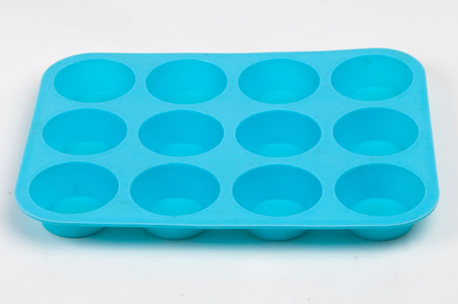 A rectangular, blue silicon patty cake tray with twelve round holes.