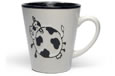A white and black mug with a handle and the image of a cow on the outside.