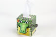 A box of tissues that looks like a green scaly crocodile; the tissues come out of its back.