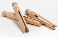 Three wooden clothes pegs with a knob at the top and a split down the middle. 