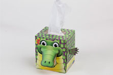 A box of tissues that looks like a green scaly crocodile. The tissues come out of its back