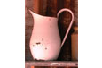 A pink rusty enamel jug with a spout and a large handle.