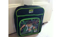 A black and green backpack with an image of Ben 10 on the side.