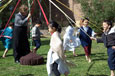 Children dancing around a maypole with the teacher holding onto the pole.