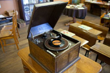 A wooden record player with an open lid and a record on the turntable