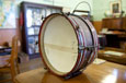 A bass drum with handle standing on a desk in a classroom