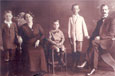 A family portrait taken in 1913 showing two adults and a young child sitting and two older children standing. 