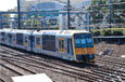 A silver electric train with yellow doors.