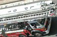 A red and white fire engine carrying ladders on its roof.