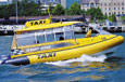 A yellow water taxi travelling on a river.
