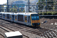 A silver electric train with yellow doors
