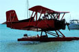 A small red sea plane resting on the water