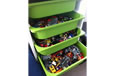 Construction toys stored in four green pull out trays.