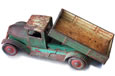 A rusty old tip truck toy made of metal.