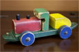 A red, green, blue and yellow wooden pull along train engine.