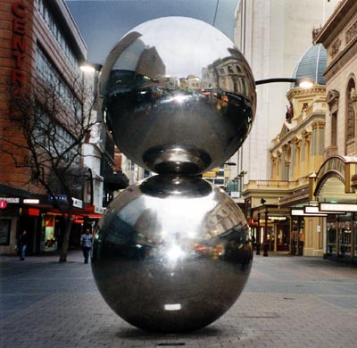 a metal sculpture of one ball on top of another