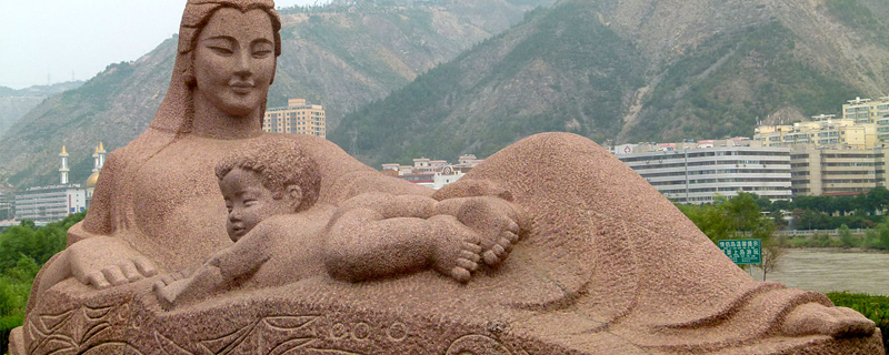 Statue of Mother Huang He Lanzhou against mountains backdrop