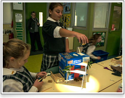 Student shining torch on shade sails