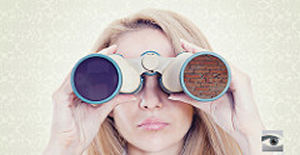 photo of woman looking through binoculars with a brick wall in one lense and a black patch in the other