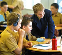 school boys looking at laptop, One wearing headphones