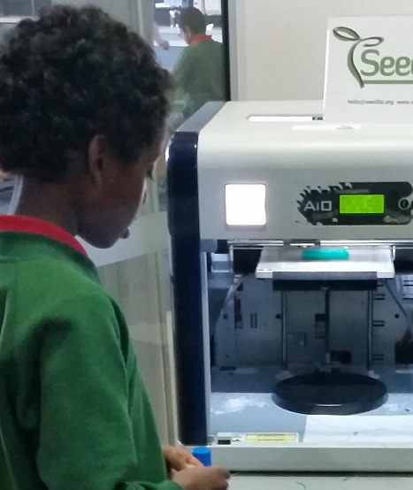 Student observing a 3D printerin the prinitng process
