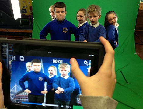 Photo of students in front of a green screen