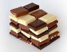 White, milk and dark chocolate squares in a piles