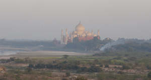 Hazy view across low plains to a large ornate building