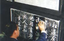 Person writing in Chinese onto a blackboard