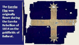 Image text: The Eureka Flag was originally flown during the Eureka Rebellion of 1854 on the goldfields of Ballarat. Link to Eureka Stockade at State Library of Victoria. Description: Dark blue background with a cross that has a star at each extremity and one at the cross section of the two axes.