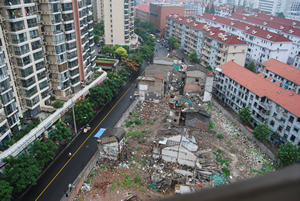 Photo of urban landscape in Shanghai showing decaying buildings surrounded by high rise apartments