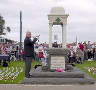 Photo of man playing the Last Post at a ceremony.