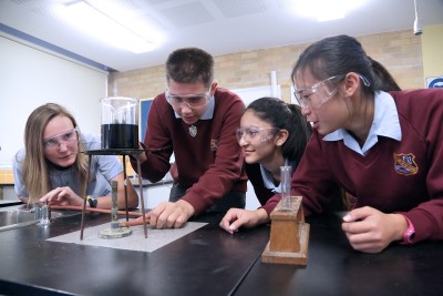 Decorative image of 4 children in a science lab conducting an experiment.