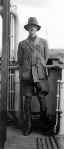 Charles Bean standing on the deck of a transport ship in full uniform.