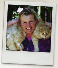 Photo of Alison Lester. She is smiling and has a fluffy, ginger cat around her shoulders.