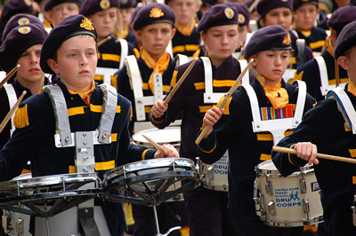 Young people in uniform marching and playing drums