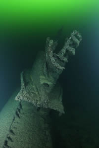 An encrusted submarine lying in green water