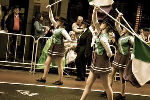 Students marching in uniform carrying flags