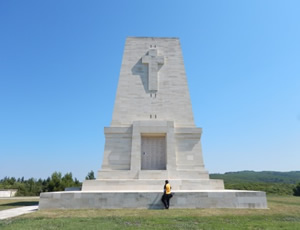 A momunment with a large cross at the top in front of a blue sky