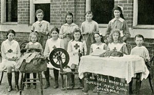 A group of youn people sitting at a table and spinning wheel.