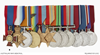 A row of medals on ribbons; the first one, the Royal Red Cross, is identified and its red cross has the words 'faith', 'hope', 'charity' and '1883' inscribed on it.
