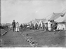 Soldiers and nurses standing in front of many tents.
