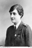 Young woman in a uniform with a Red Cross badge on the lapel.