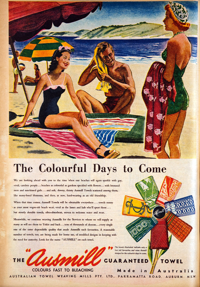 Ausmill advertisement showing two woman and one man at the beach using Ausmill  towels. Smaller inset shows fan arrangement of seven towels. Main text says 'the colourful days to come'. Secondary text reads: 'We are looking ahead with you to the time when our beaches will again sparkle with gay, vivid, carefree people ... beaches as colourful as gardens speckled with flowers ... with bronzed men and sun-kissed girls and soft, downy, thirsty Ausmill Towels scattered among them, like many-hued blossoms, and then, as now, hard-wearing as an old friendship.

When that time comes, Ausmill Towels will be obtainable everywhere ... towels sunny as your most vogue-ish beach wear, vivid as the lasses and lads who'll sport them ... but stoutly durable towels, ultra-absorbent, woven to welcome water and wear. 

Meanwhile, we continue weaving Ausmills for the Services to whom we will supply as many as will see them to Tokyo and back ... tens of thousands of dozens ... every single one of the same dependable quality that made Ausmills such favourites. A reasonable number of towels, too, are being made for home use, of modified designs in keeping with the need for austerity. Look for the name 'AUSMILL' on each towel'.