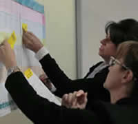 Photograph: teachers discussing and using the print NSW Literacy continuum K-10